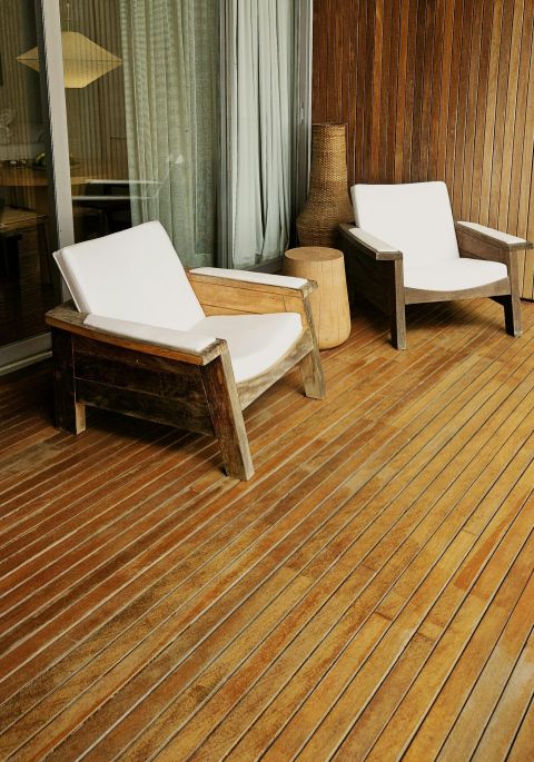 A contemporary wooden deck with stylish wooden lounge chairs for relaxation.