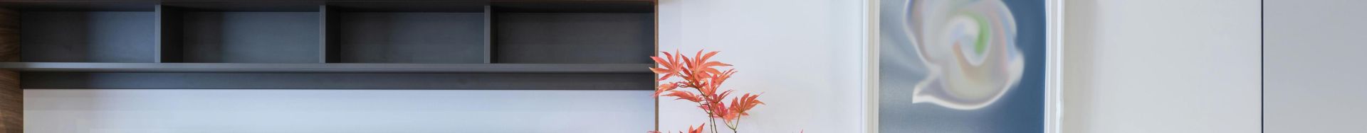 Contemporary TV set placed near cabinet and vase with flowers placed in stylish room with table in decorated apartment at home